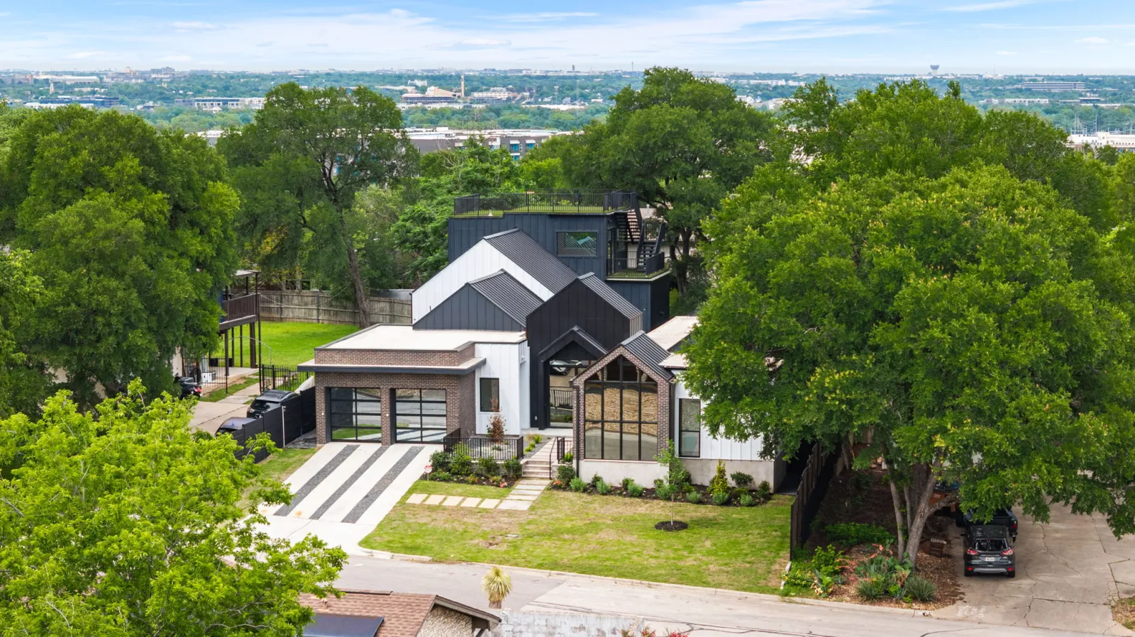 Aerial view of a modern Austin home built by CBA Design & Build, with the downtown skyline beyond