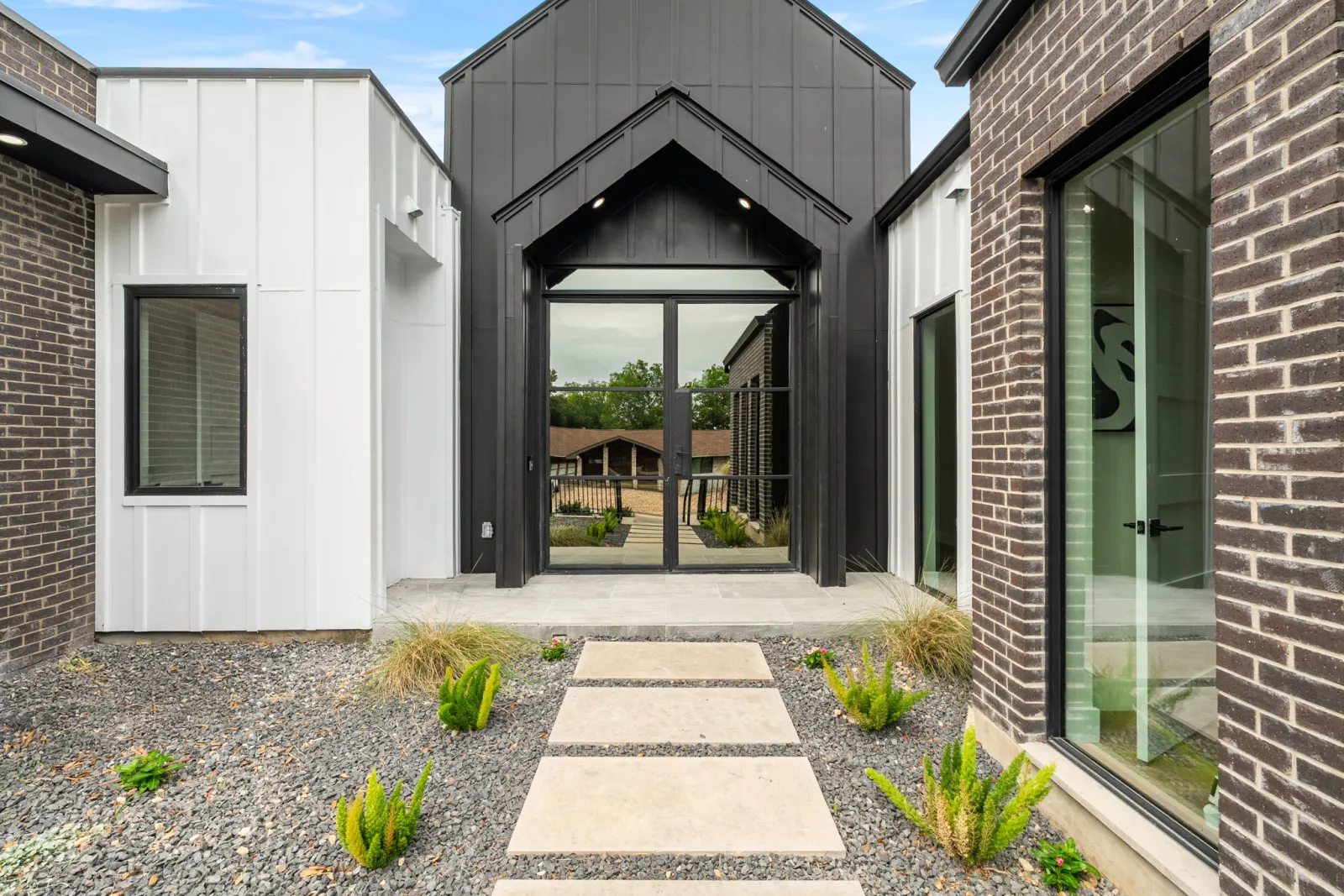 Modern black-clad entry and courtyard by CBA Design & Build